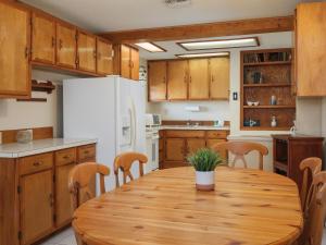 a kitchen with a wooden table and a white refrigerator at Sea Aire Oceanfront Inn in Cocoa Beach