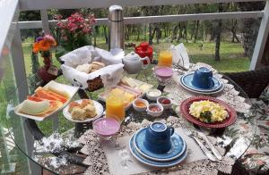 a breakfast table with food and drinks on a balcony at Chalé Bienz - Hospedagem Rural in Urubici