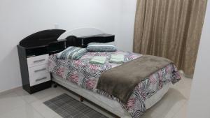 a bedroom with a bed and a dresser at Fabuloso Apto PIRATUBA in Piratuba