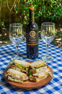 a sandwich on a plate next to two wine glasses at Dolce Uvita in Uvita