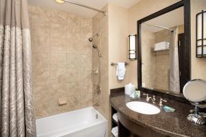 
a bathroom with a sink, mirror and bathtub at Wekopa Casino Resort in Fountain Hills
