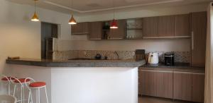 een keuken met houten kasten en een aanrechtblad bij Flat Conchas e Corais - Village Paraíso localizado em Taipu de Fora, península de Barra Grande in Barra Grande