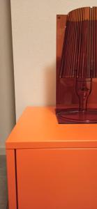 an orange dresser with a lamp on top of it at La Casa all'ombra della Chiesa in Brescello