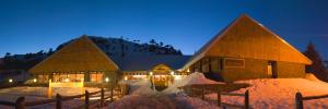un grand bâtiment recouvert de neige la nuit dans l'établissement Hotel y Cabañas del Nevado, à Caviahue