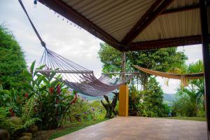 a hammock hanging from a porch of a house at Pacuare Mountain Lodge in Tres Equis