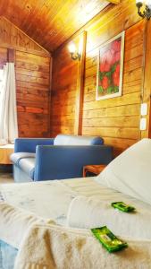 Habitación con 2 camas, sillas y una pintura en la pared. en Pousada Camping Porto Grande en Meaípe