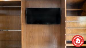 telewizor z płaskim ekranem na drewnianej ścianie w obiekcie ECONOSUITES FUNDIDORA w mieście Monterrey