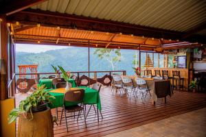 a restaurant with tables and chairs and a view of a mountain at Pacuare Mountain Lodge in Tres Equis