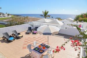 a patio with a table and chairs and the ocean at Casa Conchita in Playa Honda