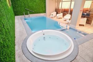 
a bath tub sitting next to a swimming pool at Hotel Denver Mar del Plata in Mar del Plata
