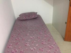 een bed met een paarse deken met roze bloemen bij Flat Conchas e Corais - Village Paraíso localizado em Taipu de Fora, península de Barra Grande in Barra Grande +38 foto's