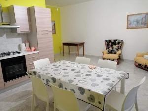 GagliatoにあるAppartamento vacanze Gagliatoのダイニングルーム(テーブル、椅子付)、キッチン