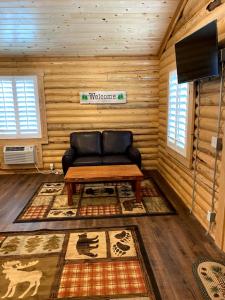 uma sala de estar com um sofá numa cabana de madeira em Cabin Village em Island Park
