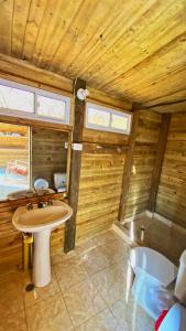 a bathroom with a sink in a wooden cabin at Hotel Cactus Taganga in Taganga