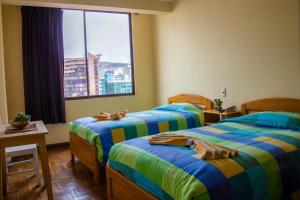 una camera d'albergo con due letti e una finestra di Downtown Hotel a La Paz