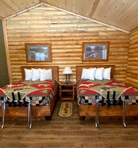 um quarto com 2 camas num chalé de madeira em Cabin Village em Island Park