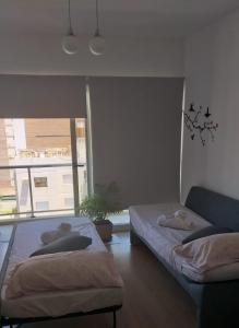 a bedroom with two beds and a couch and a window at DEPARTAMENTO TEMPORARIO ZONA PARQUE in Paraná