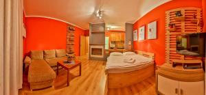 a living room with an orange wall at Apartmány Fatrapark 1 s WELLNESSOM Hrabovská dolina in Ružomberok