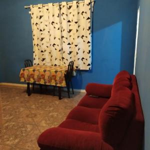 a living room with a red couch and a window at Quarto Duplo Confort in Barueri