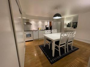Il comprend une cuisine et une salle à manger avec une table et des chaises blanches. dans l'établissement Apartment in central Kiruna 7, à Kiruna