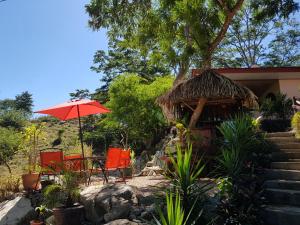 une terrasse avec une table, des chaises et un parasol dans l'établissement Cabana Luna, à Jicaral