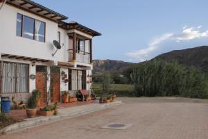 una casa con entrada y montañas al fondo en Villa del Sol - Apartamentos Turísticos, en Sáchica