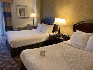 a hotel room with two beds and a chair at Radisson Hotel Austin - University in Austin
