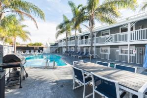 een patio met een tafel en stoelen en een zwembad bij Beach Haven in San Diego