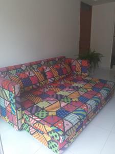 um sofá com um cobertor colorido em cima dele em Apartamento Mel do Cacau à 100mts da praia dos Milionários, Ilhéus em Ilhéus