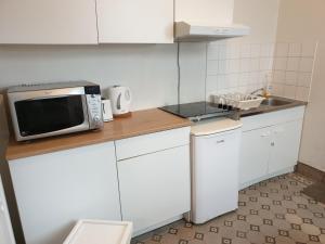 a small kitchen with a microwave on a counter at 1-2 bedroom apartments close to EU district. in Brussels