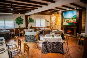 un restaurant avec des tables, des chaises et une cheminée dans l'établissement Apartamentos el Cardenillo, à Madrigal de la Vera