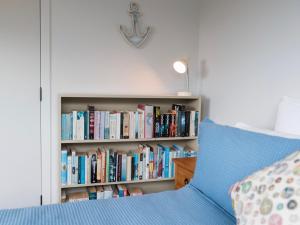 une étagère remplie de livres à côté d'un lit dans l'établissement Skipper's Haven - Opua Holiday Home, à Opua