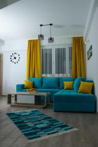 a living room with a blue couch and yellow curtains at Apartman "Park" in Livno