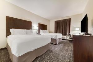 een hotelkamer met 2 bedden en een flatscreen-tv bij Cobblestone Hotel & Suites - Cozad in Cozad