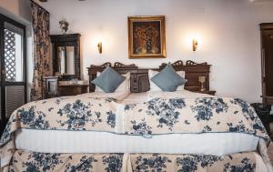 a bedroom with a large bed with blue and white sheets at Conacul Bratescu in Bran