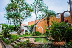 a garden with a pond in front of a house at Hotel Marques in Araras