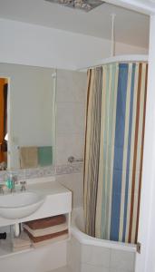 a bathroom with a sink, toilet and shower curtain at Meredith House in Swansea
