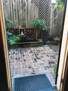 an entrance to a patio with a fence and plants at The Courtyards in New Orleans