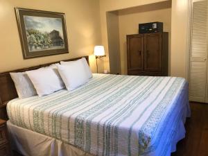 a bedroom with a bed with a blue and white comforter at The Courtyards in New Orleans