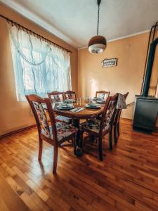 a dining room with a wooden table and chairs at Holiday home Srdašce in Perković