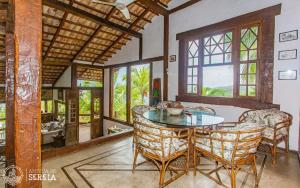 a dining room with a glass table and chairs at Casa Yacht Club in Ilhabela