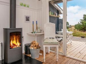 ファーンにあるHoliday home Fanø XIXのポーチ(暖炉、テーブル、椅子付)