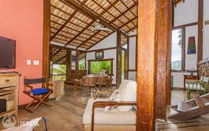 a living room with a couch and a tv at Casa Yacht Club in Ilhabela