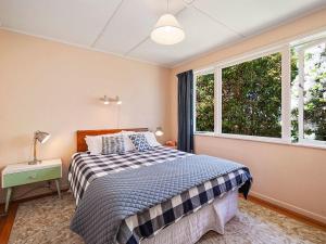 um quarto com uma cama e uma janela em Te Kopua - Acacia Bay Holiday Home em Taupo