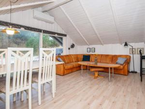 a living room with a couch and a table and chairs at 6 person holiday home in Ringk bing in Klegod