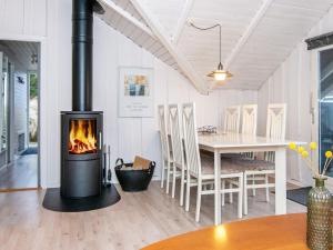 a fireplace in a living room with a dining room table at 6 person holiday home in Ringk bing in Klegod