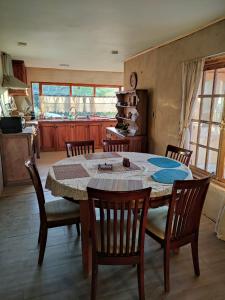 a dining room with a table and chairs and a kitchen at Casa de Adobe Remanso del Espíritu in Isla de Maipo