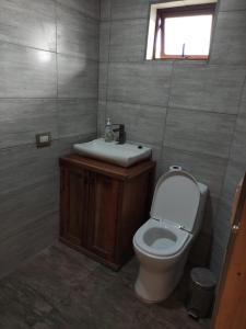 a bathroom with a toilet and a sink at Casa de Adobe Remanso del Espíritu in Isla de Maipo