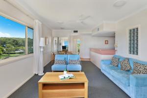 a living room with blue couches and a table at Alex Seaside Resort in Alexandra Headland +73 photos
