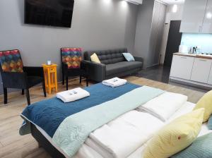 uma sala de estar com uma cama grande e um sofá em Apartamentylove - Apartament Kiliński em Lódź